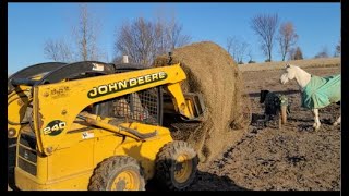 Putting a New Round Bale in the Feeder for the Horses with the John Deere 240 Skid Steer [upl. by Telimay361]