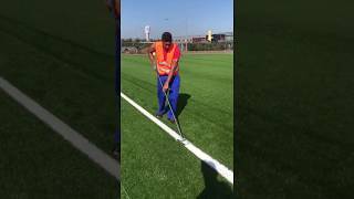 Installing the white lines of an artificial grass football pitch [upl. by Cristionna]