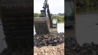 Excavator clearing riverbed stones process [upl. by Ander]