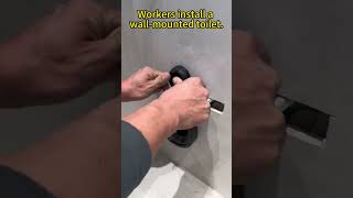 Workers install a wallmounted toilet [upl. by Hgierb]