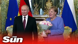 Vladimir Putin gives Angela Merkel flowers as they meet in Kremlin [upl. by Harrak]