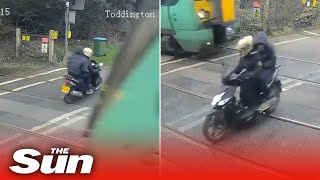 Two people on a moped narrowly avoid being hit by a 70mph train after riding level crossing [upl. by Haimirej]