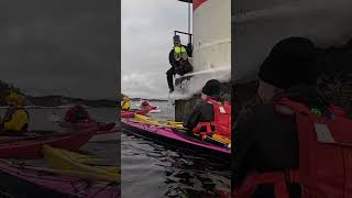 Kayak leader climbing down onto kayak from lighthouse  sea kayaking in winter [upl. by Edlun643]